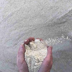 Hands full of white sand